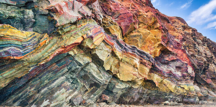 Dramatic colorful rock formation with folded geological strata and mineral deposits formation sedimentary colorful geological landscape mountain background cliffside earthscience