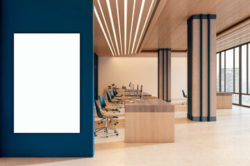 Naklejka premium Blank vertical poster mockup on blue wall in modern corporate office interior with wooden desks, clean design, bright lighting and contemporary room ambience. 3D Rendering
