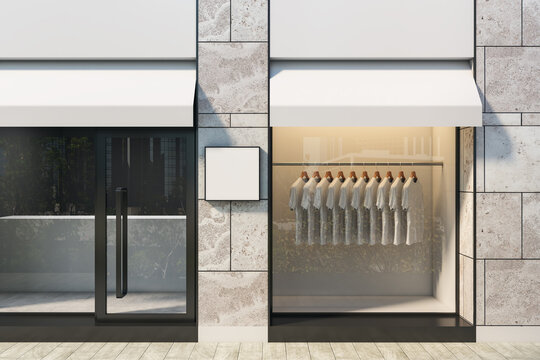 Modern retail shop facade with blank square signage and clean storefront window displaying hanging clothes on contemporary building exterior. 3D Rendering