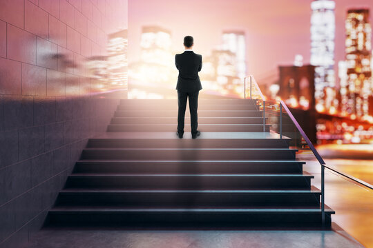 Business figure atop lit staircase facing glowing city skyline symbolizing success growth and elevate concept in abstract setting.
