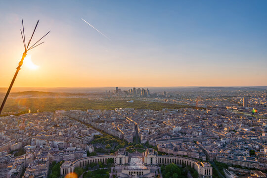 Partial solar eclipse on the horizon over the Paris cityscape with the Trocadero and the La D&eacute;fense financial district at sunset as seen from the Eiffel Tower.