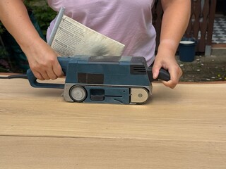 DIY Woodworker Smoothing Tabletop with Power Sander © Jenny Sturm
