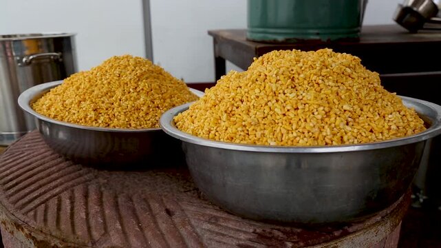 Metal bowls filled with yellow split lentils on rustic kitchen stove