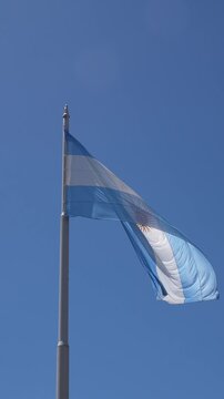 Beautiful national flag of Argentina waving on a tall flagpole, representing a symbol of national pride