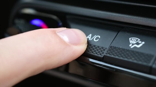 Young woman turns on car air conditioner on climate control panel to cool cabin and improve comfort during summer car drive