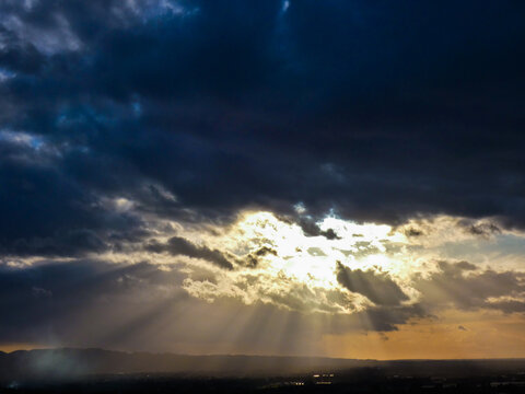 Evening landscape where the sun's rays pierce a gray cloud in Provence in France