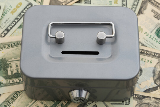 Silver lock box on American money for financial security and savings