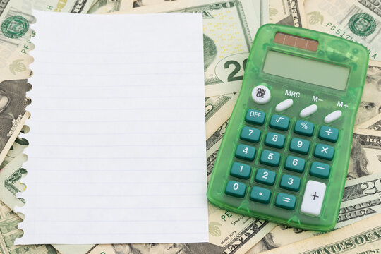 Calculator with torn paper on twenty dollar bills for budgeting