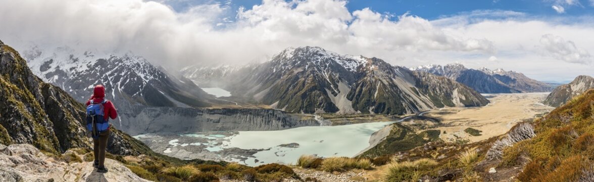 Hiker standing on rocks, view into the Hooker Valley from Sealy Tarns Track, glacial lakes Mueller Lake and Hooker Lake, Mount Cook National Park, Canterbury Region, South Island, New Zealand