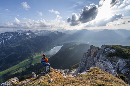 Hiker at the summit of Schartschrofen at sunset, view of Haldensee and Allg&auml;u Alps, Tannheimer Berge, Allg&auml;u, Bavaria, Germany