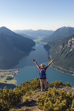 Young hiker, woman looking into the distance, view from B&auml;renkopf mountain to Lake Achen, left Seebergspitze and Seekarspitze, right Rofan Mountains, Tyrol, Austria