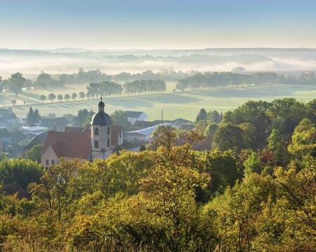 Morning atmosphere in the Saale valley near the village of Eulau with village church in autumn, fog sweeping through the rows of trees in the valley, Naumburg, Saxony-Anhalt, Germany