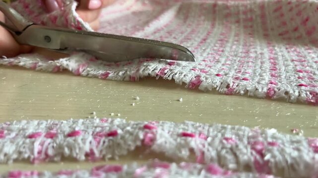 Tailoring Process Cutting Fabric Strips. Fabric Cutting Process for Fashion Production. Hand Cutting Fabric Strips for Garment Making. Dressmaking Process with Tweed Fabric. 