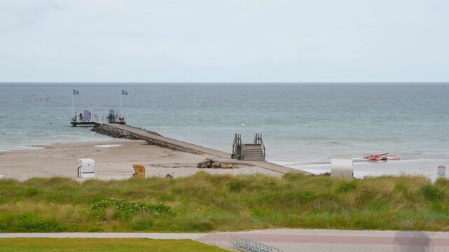 time-lapse of Baltic Sea beach life with long expusure motion blur of people, stone jetty in Stein near Laboe in Germany, Schleswig-Holstein, summer 2026