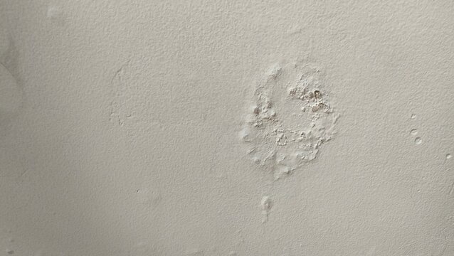 Close-up of a damaged interior wall with peeling paint and bubbles caused by water leakage. Concept for building maintenance, home renovation, moisture problems, and structural damp issues
