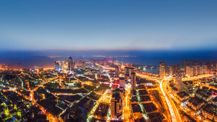 Fototapeta premium Night View Of Coastal Urban City With Illuminated Buildings And Roads