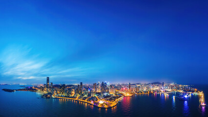 Fototapeta premium Night View of Coastal Urban Skyline with Illuminated Buildings