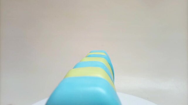 Soap bar. blue and yellow soap bars for bath in a row rotating on white background. aromatic soap for body and face. pieces of blue and yellow bathing soap.