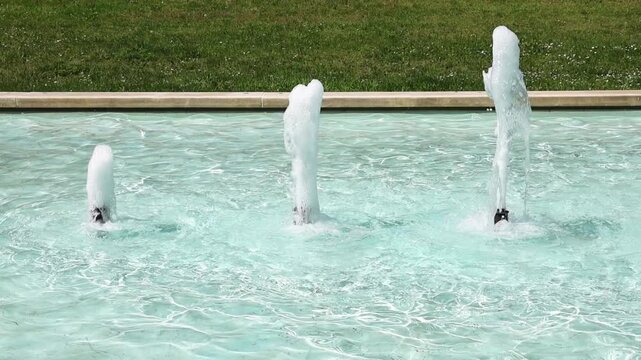 Water jets dancing in a garden fountain in super slow motion