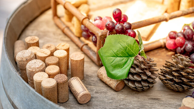 Group of wine corks, pine cones and grape bunches decorating over wooden wine tank. Element for restaurant bar decoration during Christmas celebration