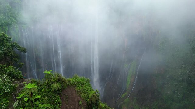 Tumpak Sewu Waterfall Surrounded by Tropical Clouds | Drone View Java Island Indonesia
