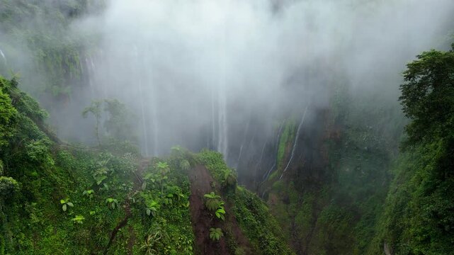 Aerial Perspective of Tumpak Sewu Waterfall and Cloud Covered Canyon &ndash; Java Island Indonesia
