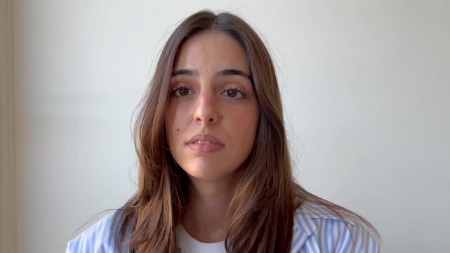 Beautiful businesswoman confidently talking and gesturing during an online video call meeting, engaging with the screen from her home office with a positive and professional attitude