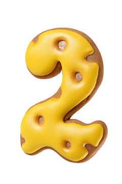 Gingerbread cookie shaped as a number two with bright yellow icing isolated. Transparent PNG image.