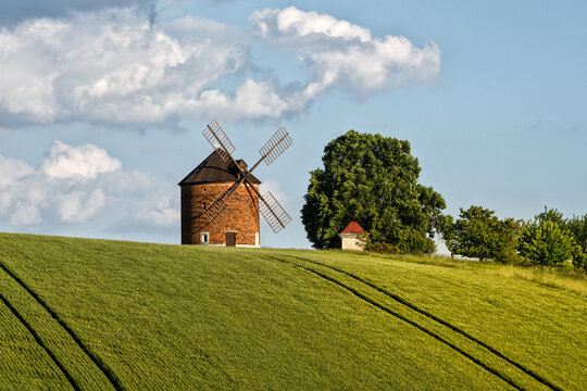 Historic Chvalkovice windmill in a vibrant spring landscape with green field