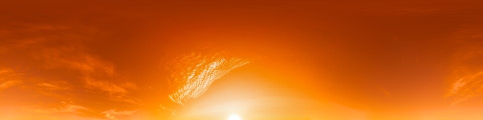 Obraz premium Sunset sky panorama showing vibrant orange clouds during golden hour with a bright sun on the horizon