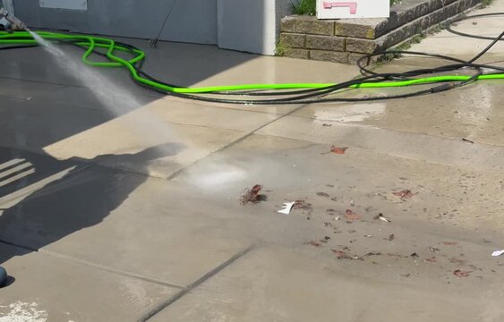 Powerwashing leaves and debris from sidewalk