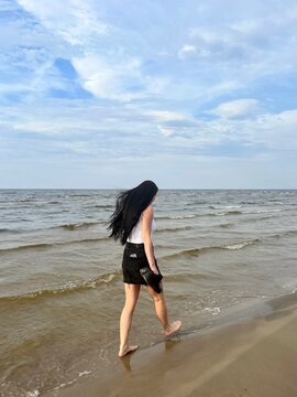 a girl walks along the sea