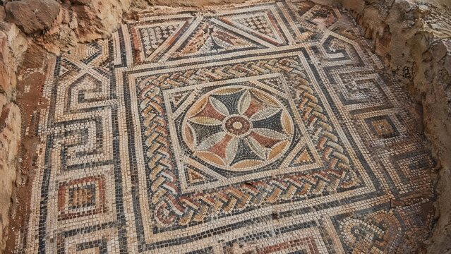 Close-up of ancient mosaic floor with geometric patterns, archaeological texture.