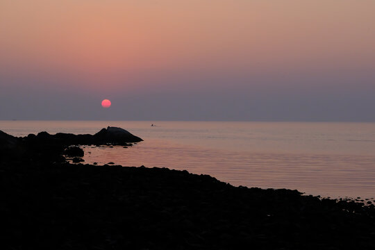 Fishermen silhouetted against a sunset in Goa, India 