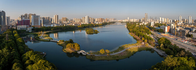 Naklejka premium Panoramic View of Nanning Cityscape with Lake and Urban Skyline at Sunset