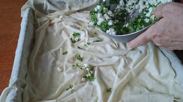 Preparing Traditional Turkish Cheese Borek with Fresh Parsley and White Cheese Filling