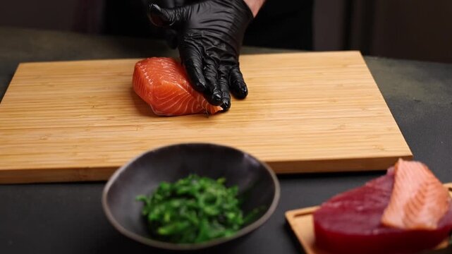 Close-up of a chef slicing fresh salmon on a wooden cutting board. Sharp knife, detailed texture of raw fish, and professional kitchen atmosphere emphasize precision, freshness, and gourmet culinary p