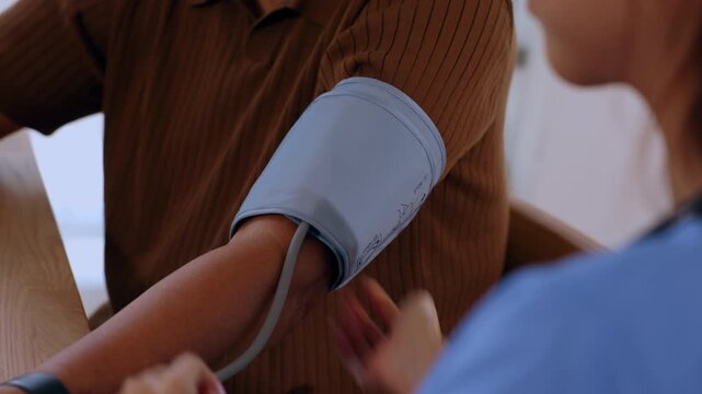 Blood pressure cuff on arm patient in clinic medical examination healthcare doctor checkup with child foot shoe clothing closeup casual health care measurement