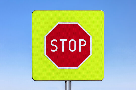 "Stop" road sign on a fluorecscent lime green background.
