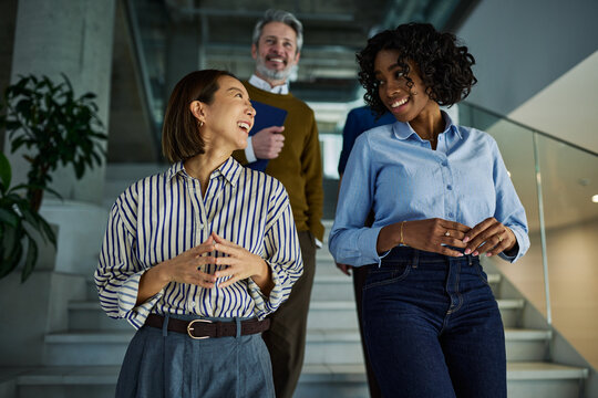 Diverse business people discussing in modern office staircase