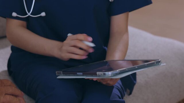 Healthcare worker tablet nurse technology medical uniform hand typing on screen digital record clinic communication patient care workflow with clipboard form pen stylus support