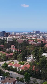 Westwood Los Angeles neighborhood showcasing UCLA campus with downtown buildings, residential homes, and green trees under clear blue sky