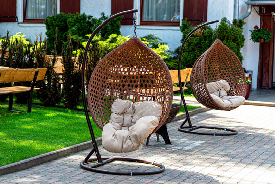 Hanging wicker egg chairs providing outdoor garden relaxation