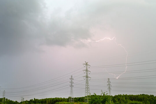 Lightning striking above power lines during a summer storm