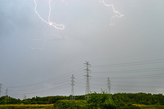 Storm lightning striking sky over power lines