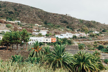 Obraz premium View of a village at the foot of a mountain on a volcanic island.