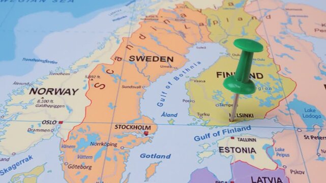 Green pushpin on map marking Helsinki Finland with surrounding countries like Sweden Norway Estonia.