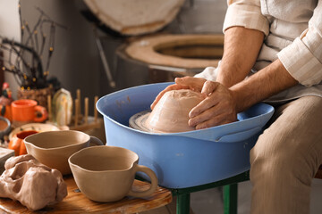 Skilled artisan hands shaping wet clay on a pottery wheel, crafting ceramic art in a workshop setting, this traditional craft involves careful sculpting and forming of earthenware © Pixel-Shot
