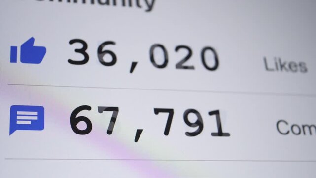 A close-up shot of social media metrics displaying high counts of likes and comments with blue icons on a screen.