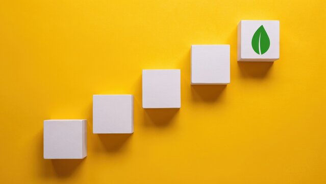 Ascending white blocks with green leaf on top on yellow